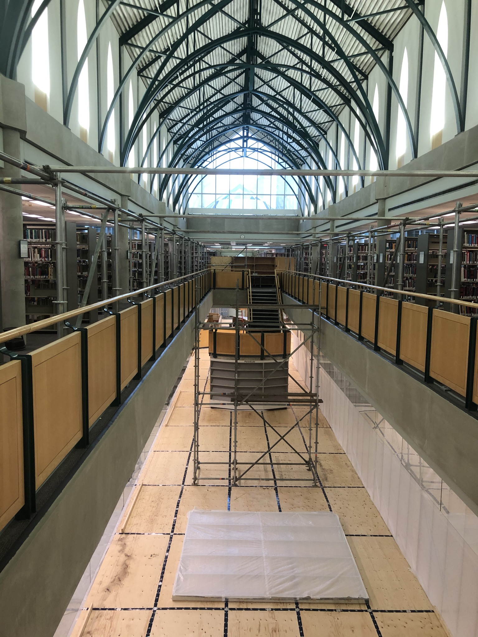 A photograph from the third floor of the library looking down at the staircase in building 7. Scaffolding is surrounding the staircase.