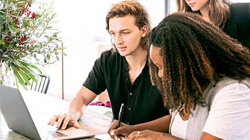 Three people working together on a laptop